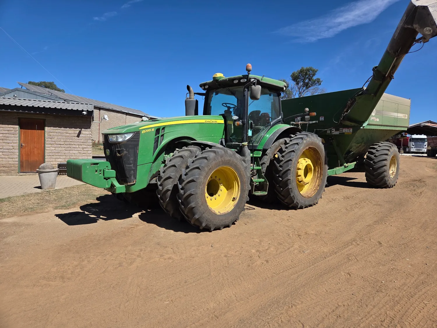 John Deere tractor attached to a grain cart