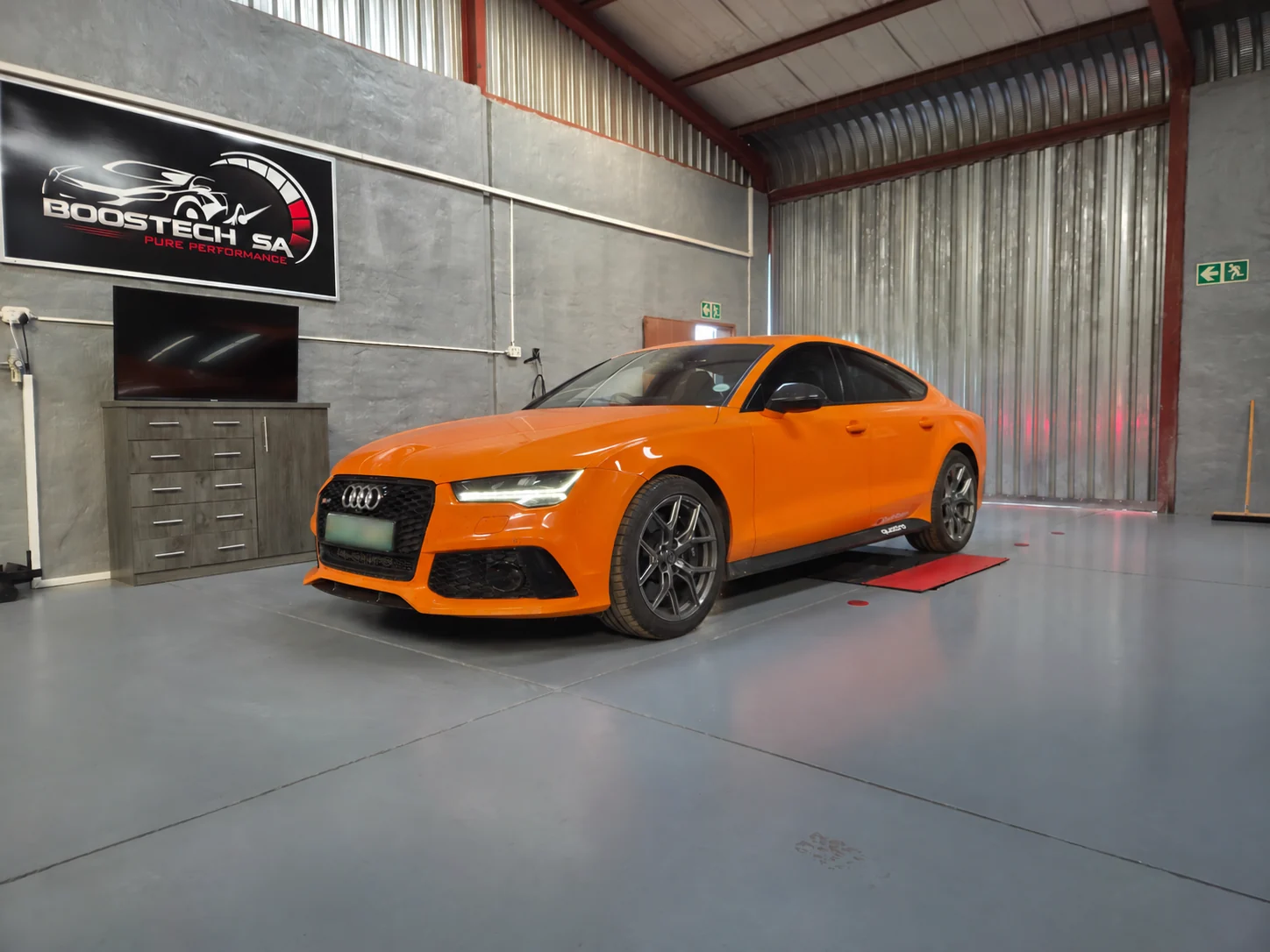 Orange Audi in the Boostech workshop, showing passenger-car tuning alongside bakkie applications