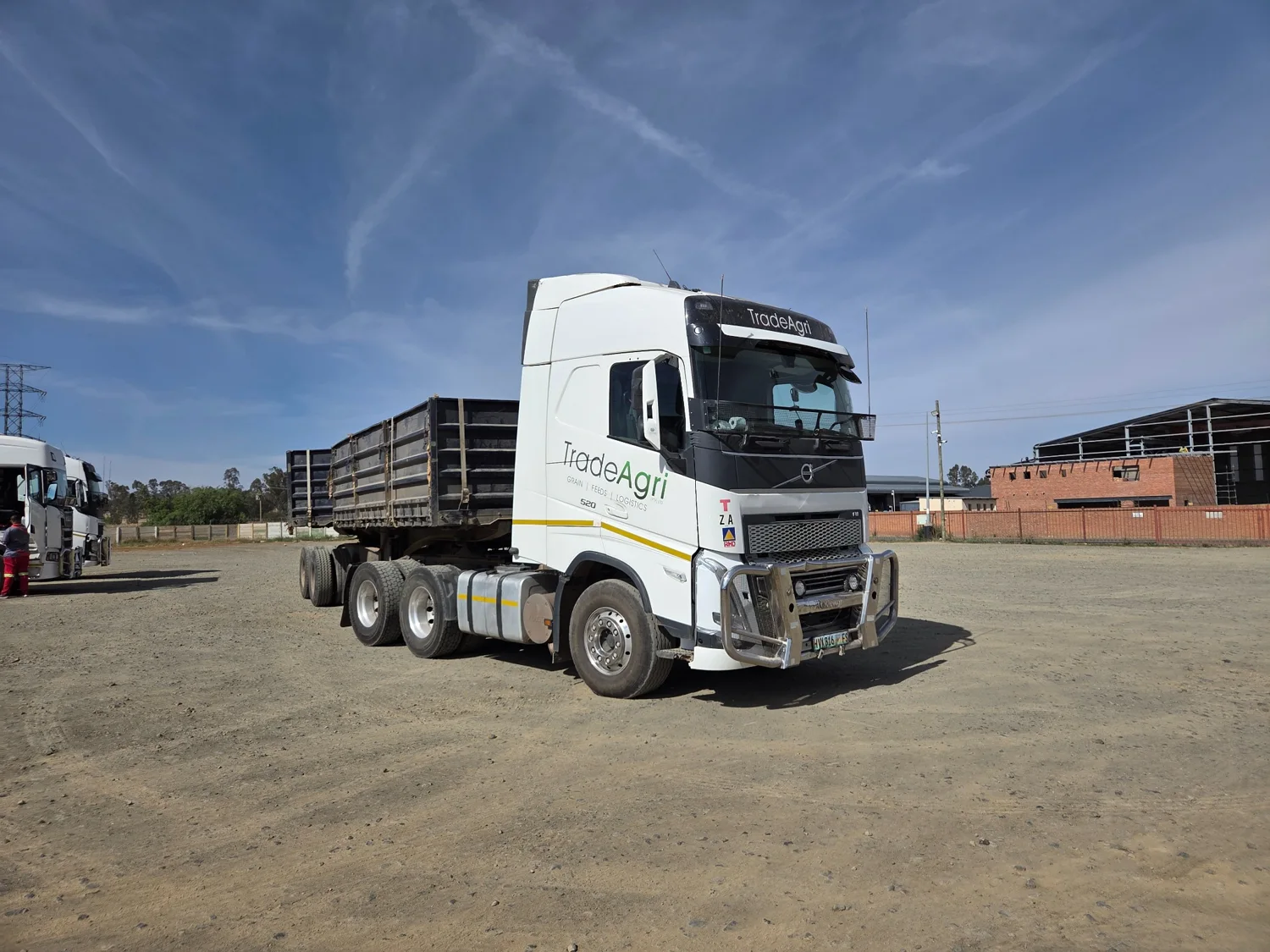 White Volvo FH 520 with a tipper trailer at a transport yard
